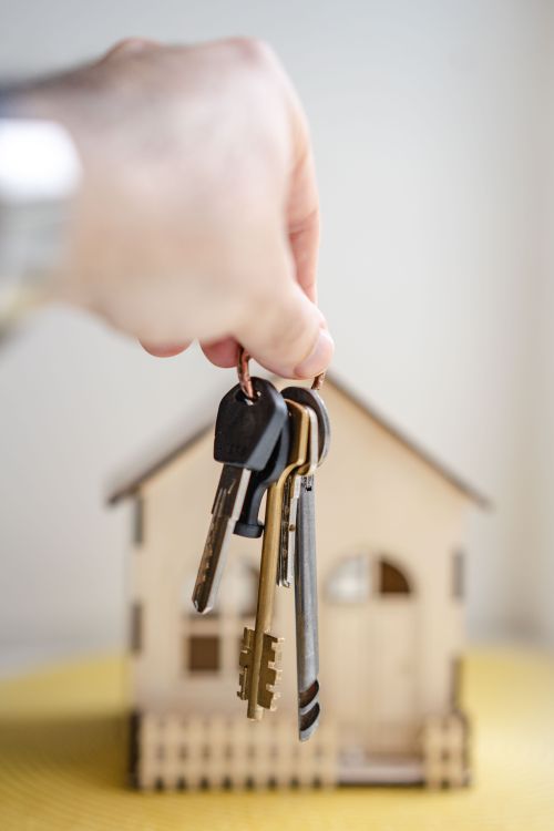 House keys held in front of a new home